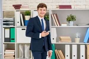 handsome-businessman-posing-in-office-FH3U3GD-scaled-e1601654805534.jpg